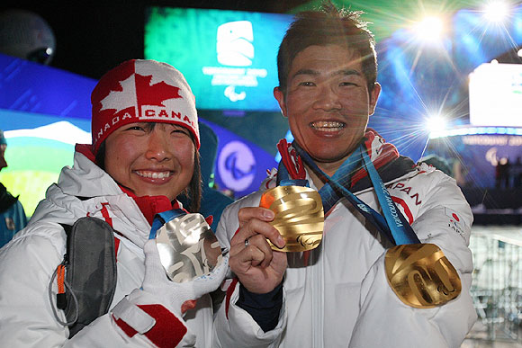 ［写真］笑顔の新田佳浩選手と太田渉子選手、金メダル、銀メダルを手に。